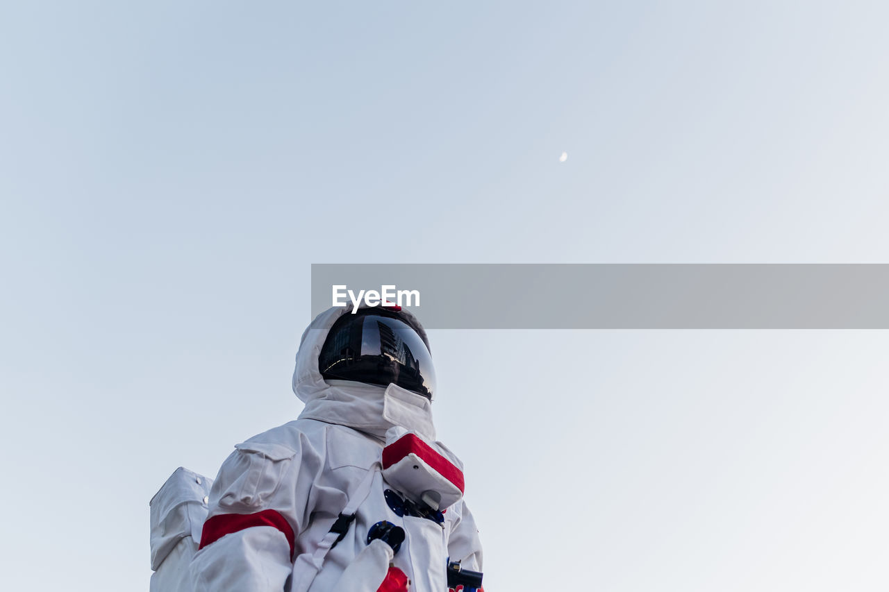 Mid adult man standing below sky