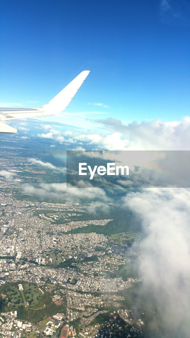 CROPPED IMAGE OF AIRPLANE WING OVER LANDSCAPE