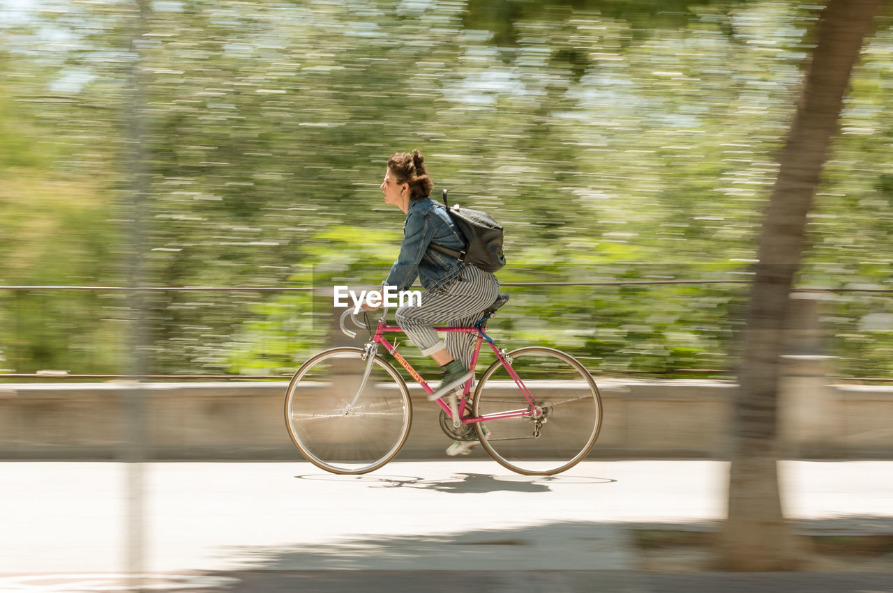 YOUNG WOMAN RIDING BICYCLE ON WATER