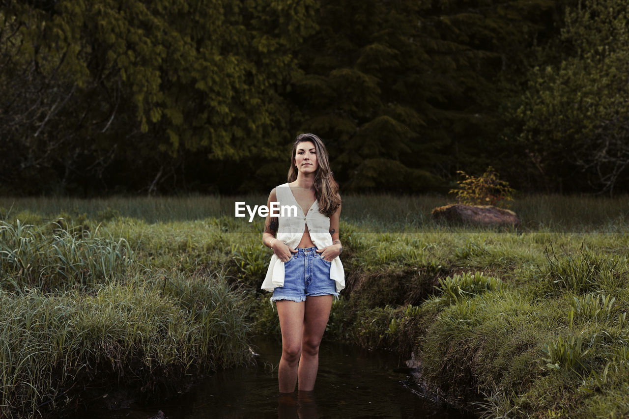 Natural beauty with tattoos in a meadow in ucluelet