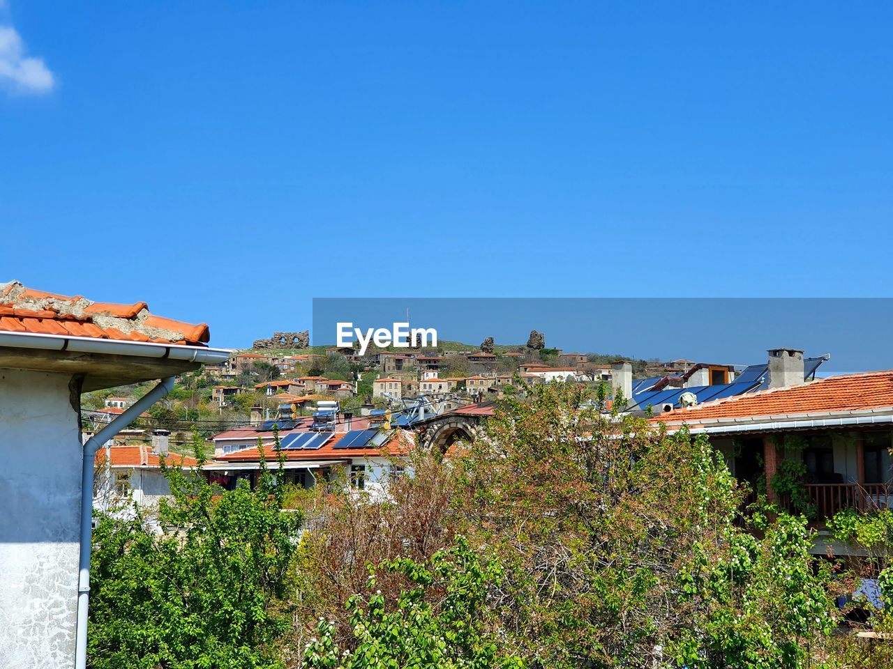 Houses and buildings against clear blue sky