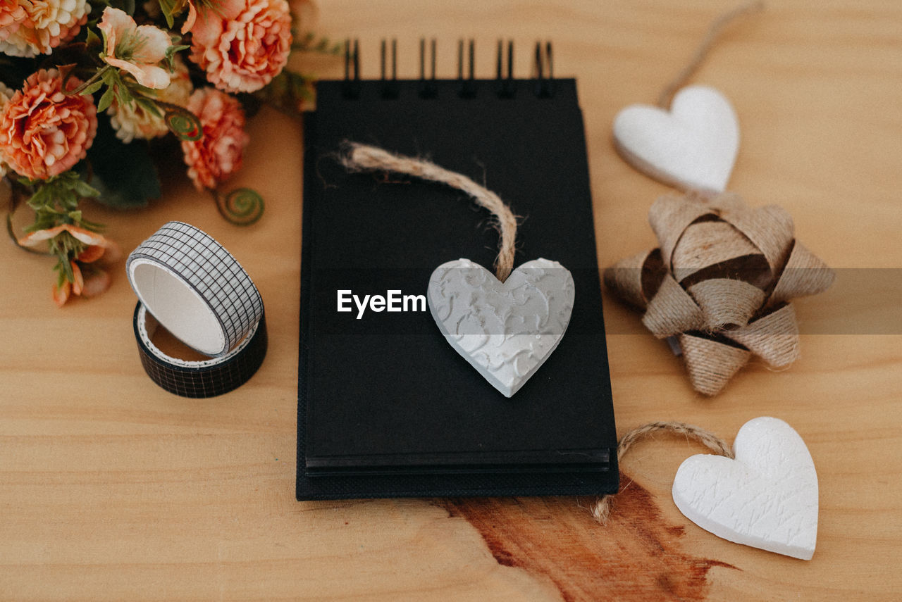 heart shape, wood, indoors, table, high angle view, no people, flower, love, still life, plant, emotion, positive emotion, flowering plant, creativity, directly above, arrangement, nature, decoration, art, food and drink, craft, petal, valentine's day, paper, knolling - concept, food, studio shot