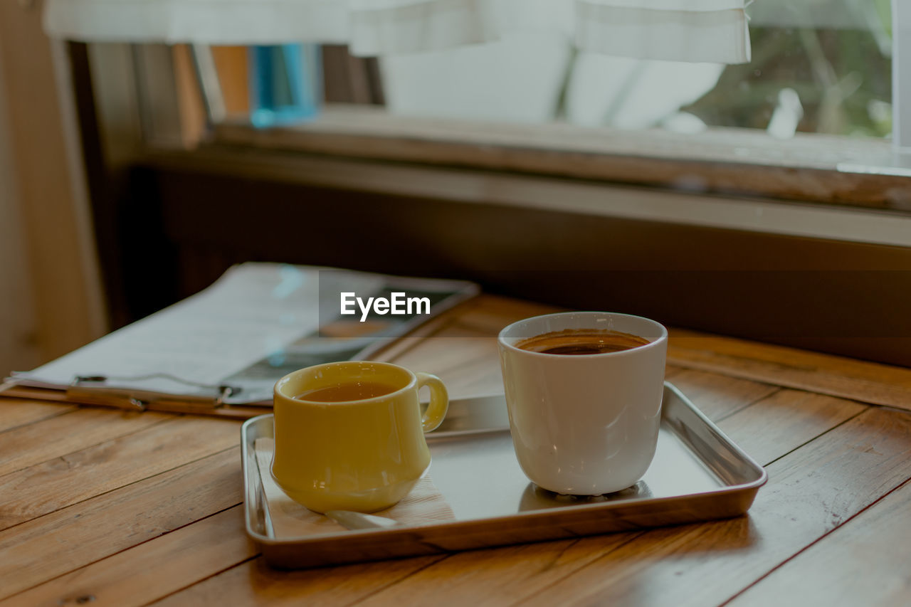 CLOSE-UP OF COFFEE CUP AND TABLE