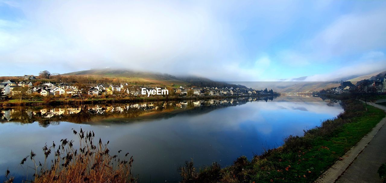 Scenic view of lake by mountains against sky