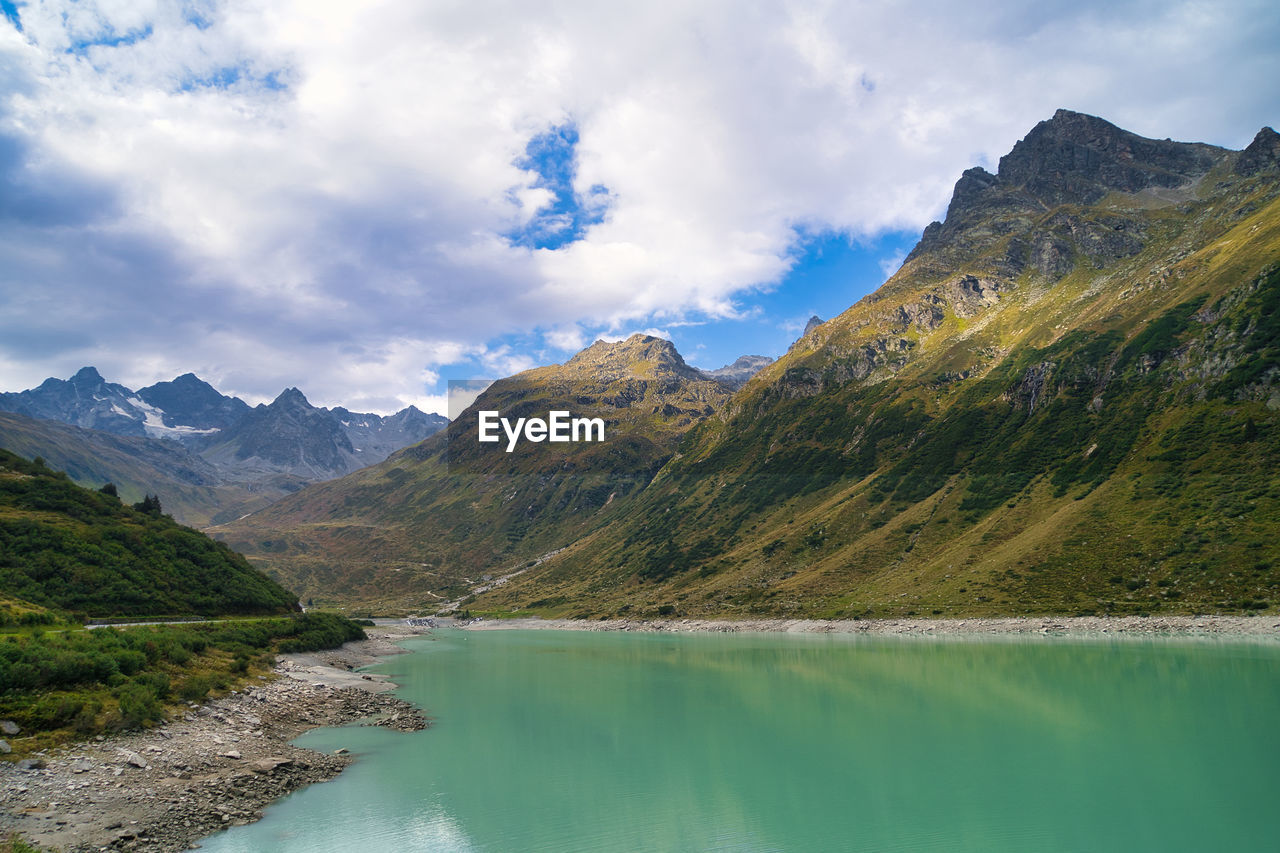 SCENIC VIEW OF LAKE BY MOUNTAIN AGAINST SKY