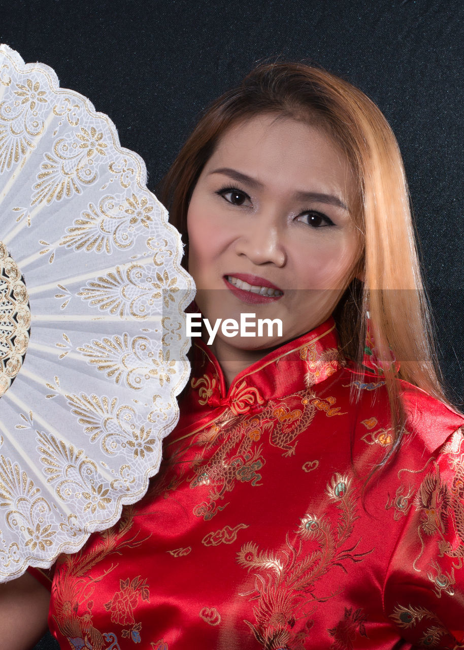 PORTRAIT OF A SMILING YOUNG WOMAN WITH RED EYES