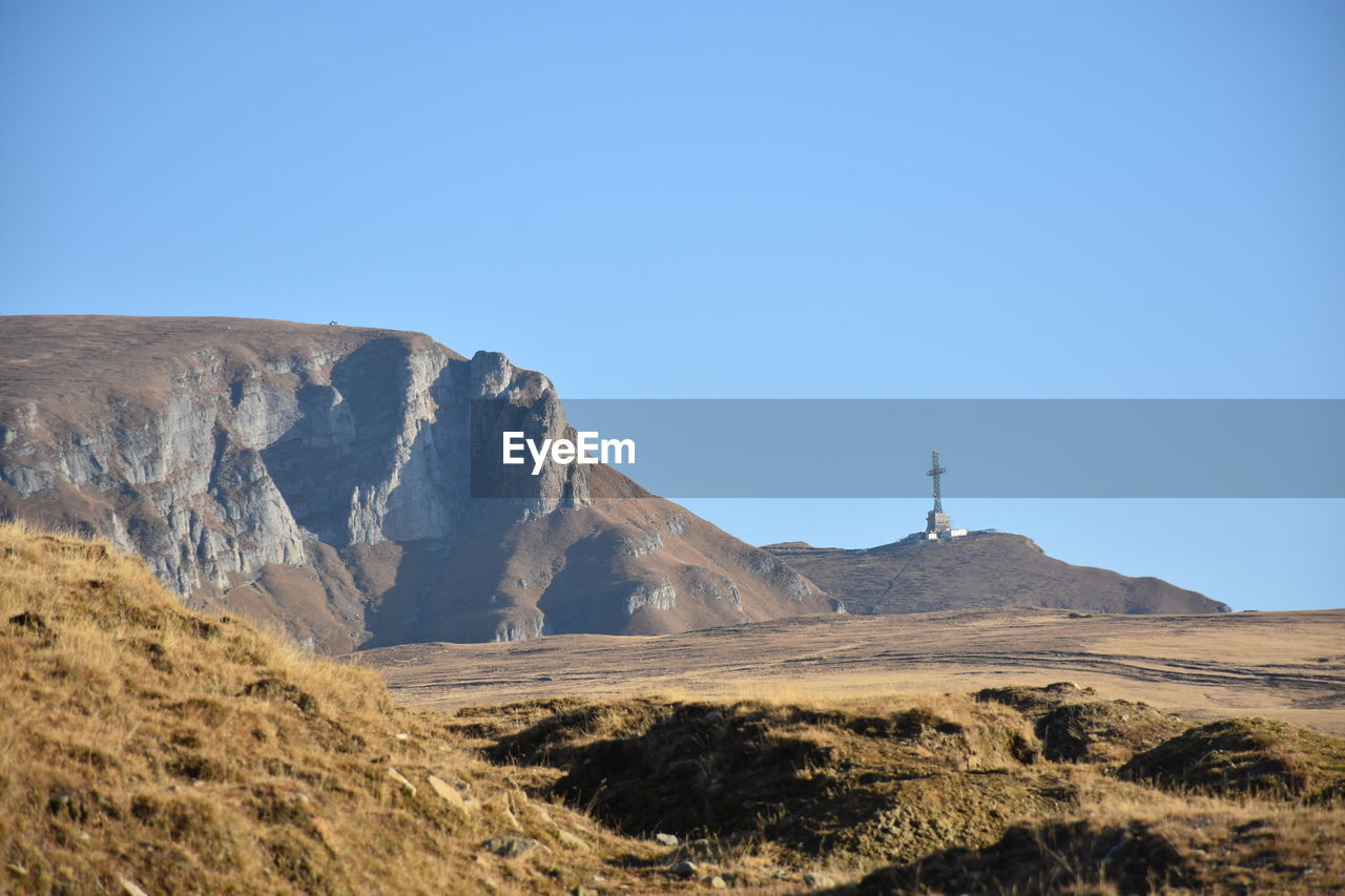 Scenic view of arid landscape against clear blue sky