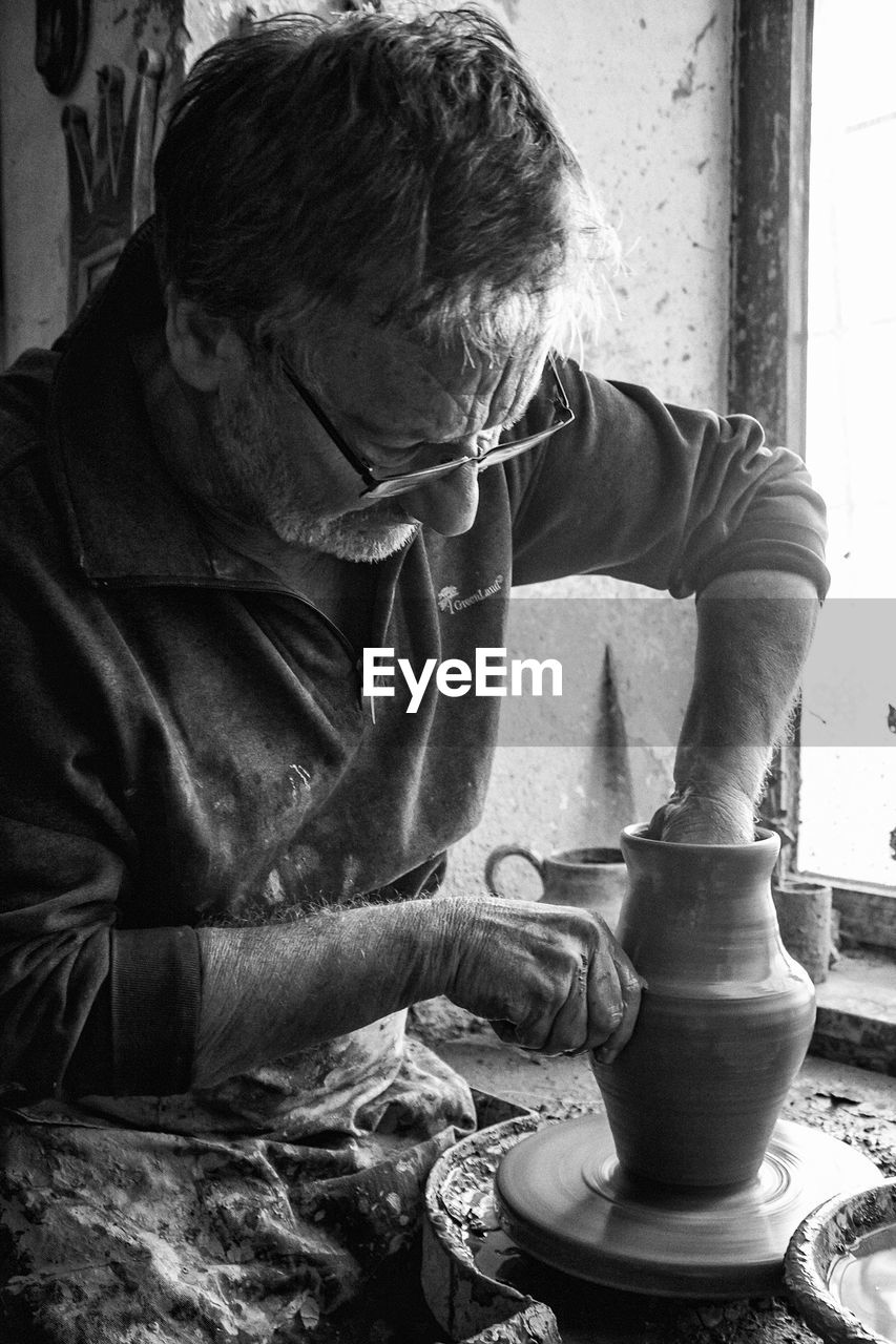 CLOSE-UP OF MAN WORKING IN KITCHEN