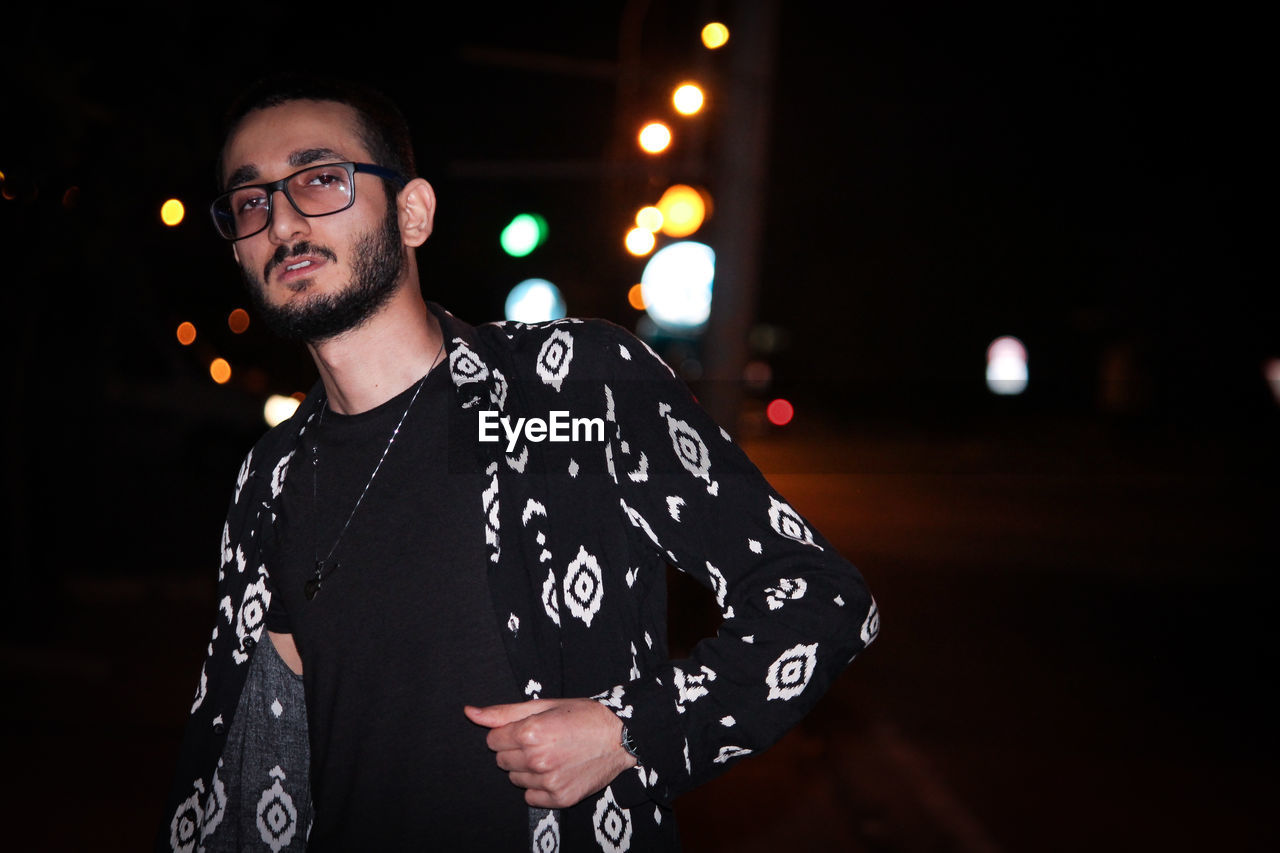 Portrait of young man standing at night