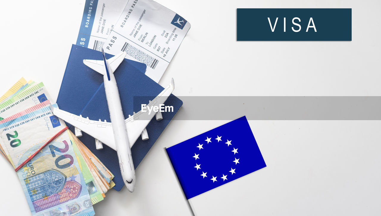 Flag of european union with passport and toy airplane on wooden background. flight travel concept