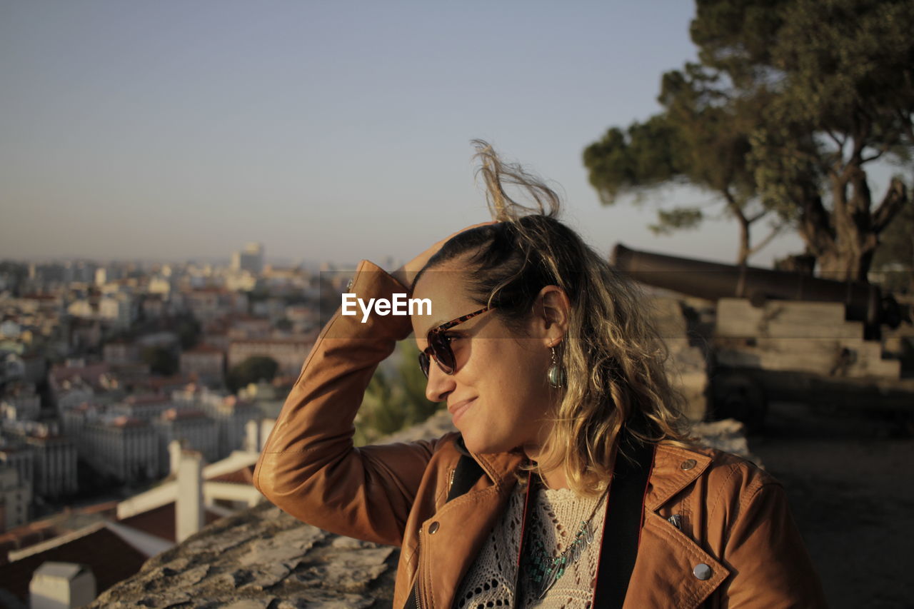 Smiling woman looking away against sky