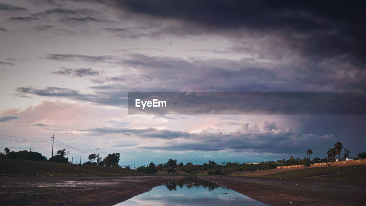 SCENIC VIEW OF RIVER AGAINST SKY AT SUNSET