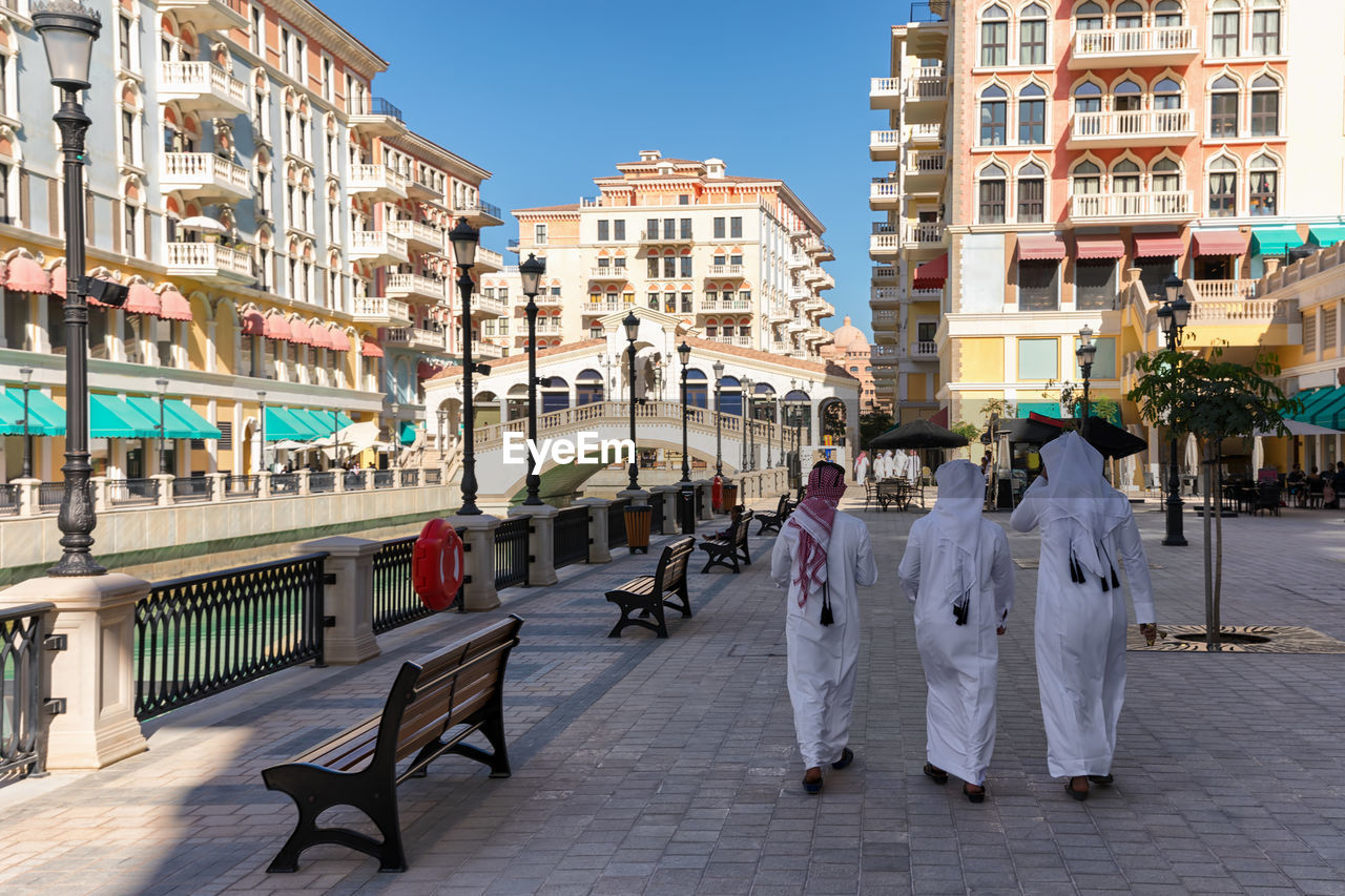 Rear view of women in traditional clothing walking on street in city