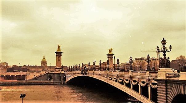 BRIDGE OVER RIVER WITH CITY IN BACKGROUND