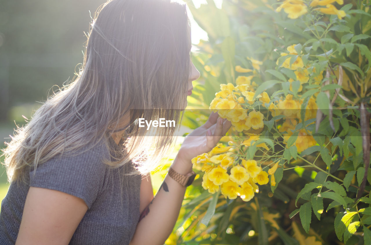 Midsection of woman against yellow flowering plants