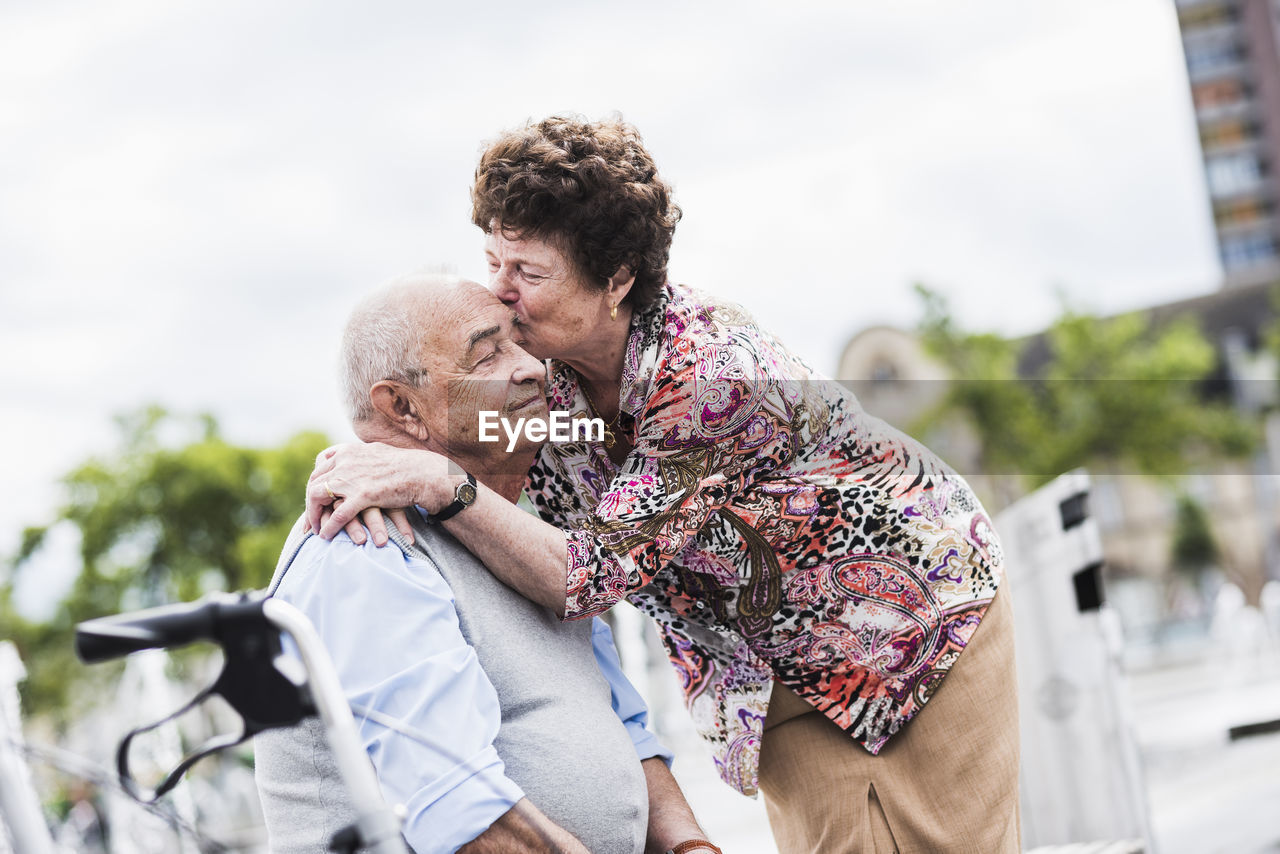 Senior woman kissing her husband