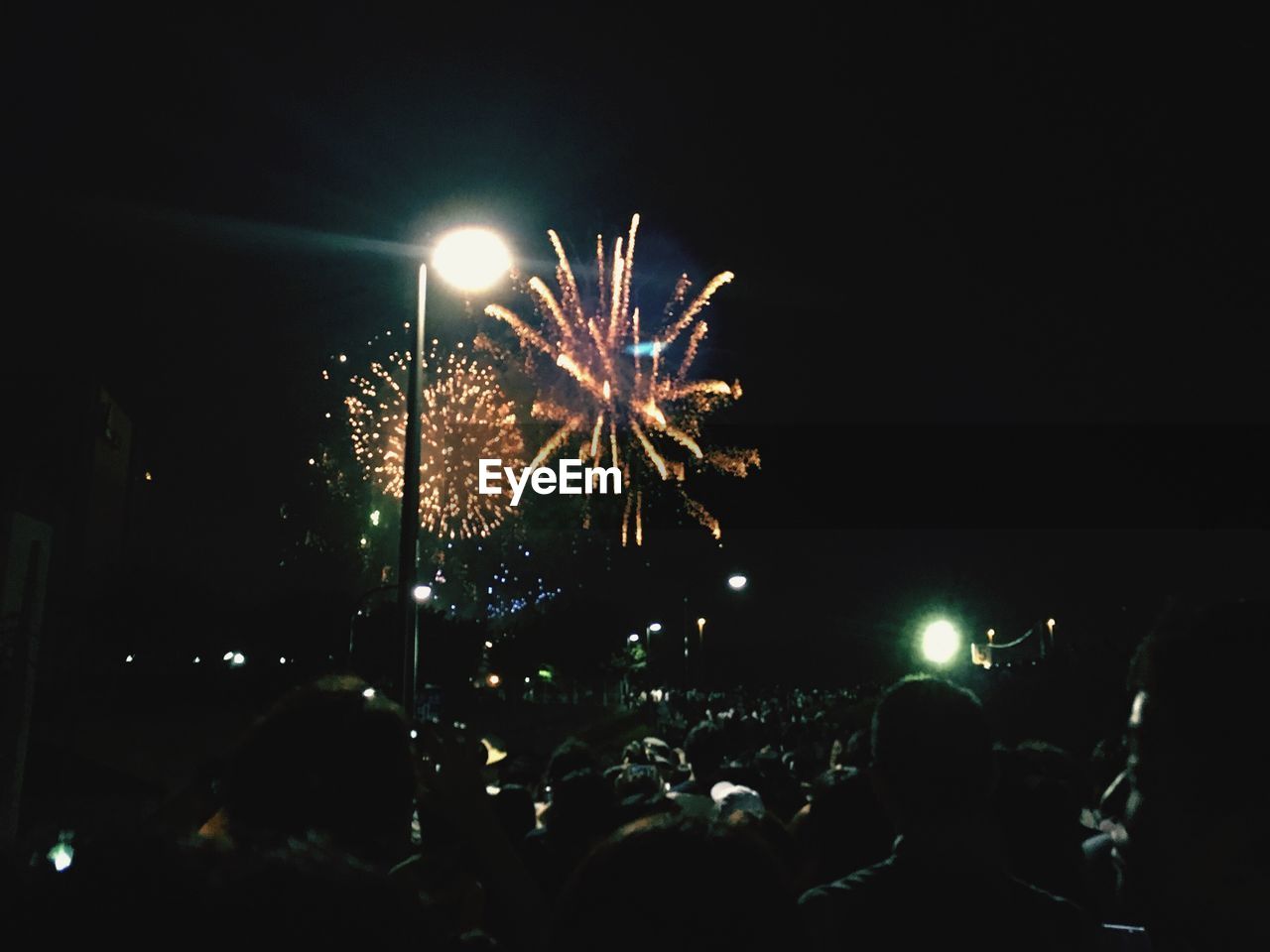 PEOPLE ENJOYING FIREWORKS DISPLAY