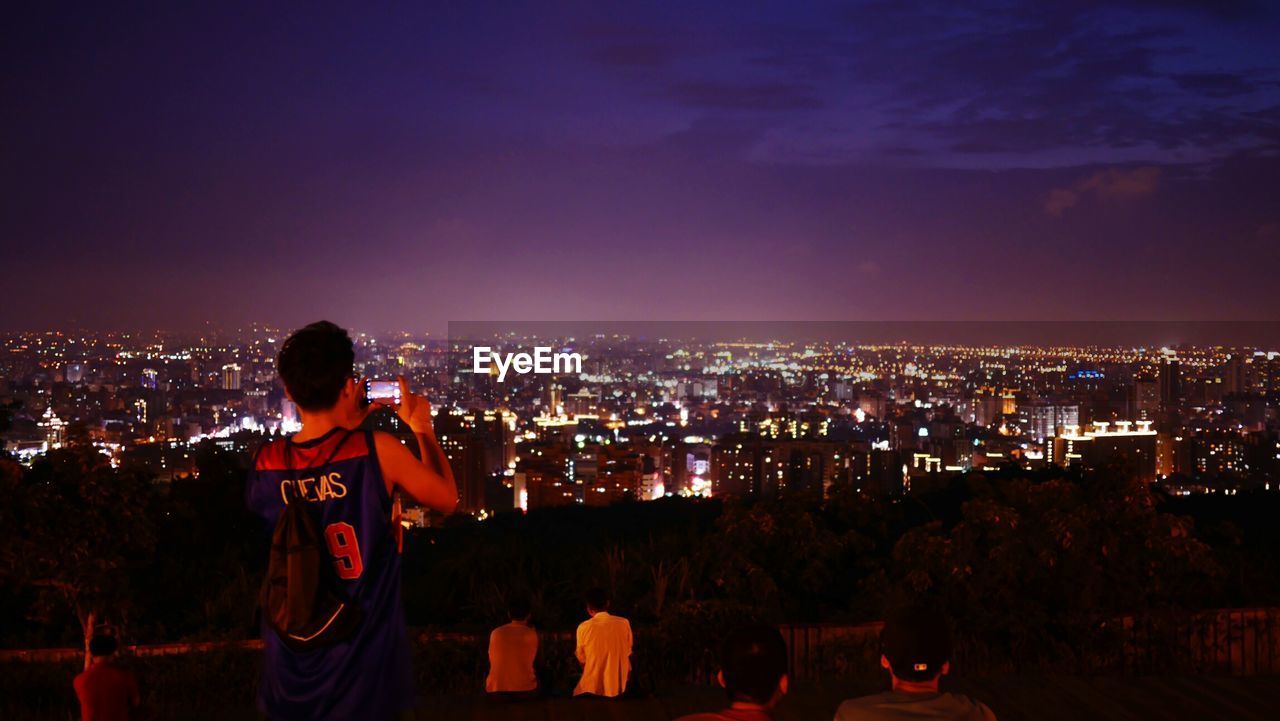 VIEW OF ILLUMINATED CITYSCAPE AT NIGHT