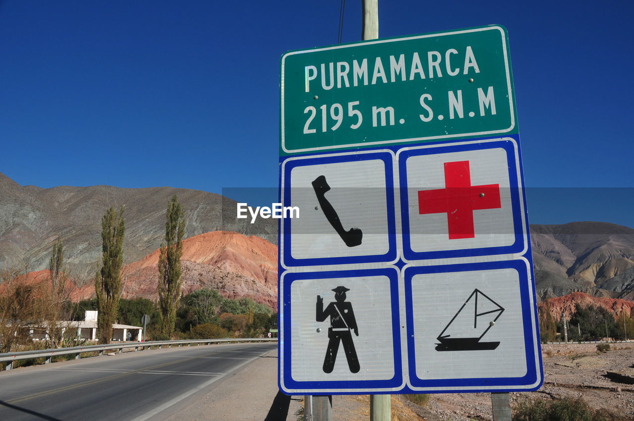 Road sign against clear blue sky