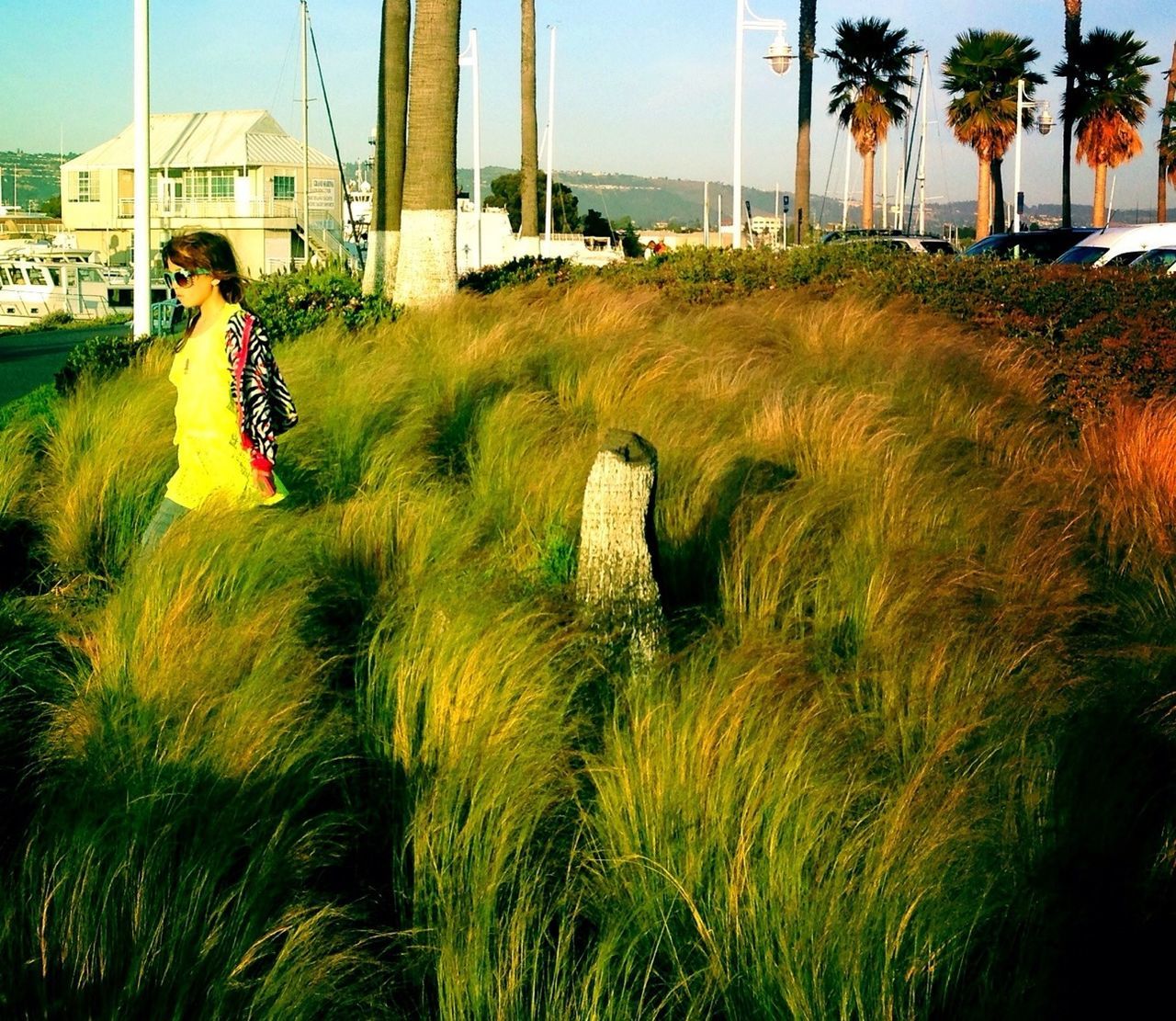 WOMAN STANDING ON GRASSY FIELD