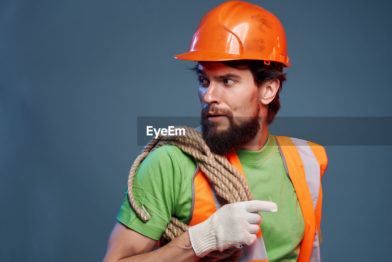 Man working against orange background