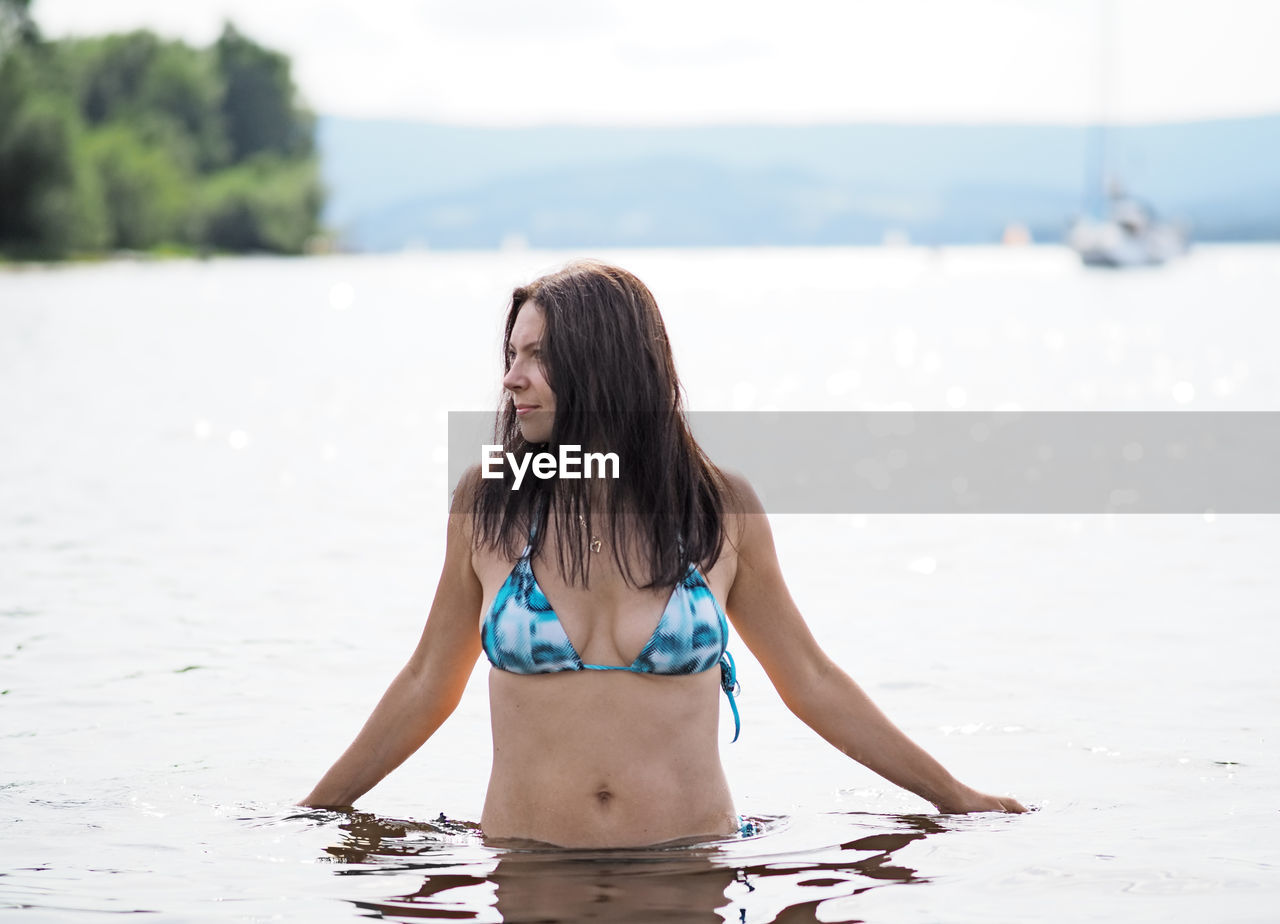 Young woman swims in the lake