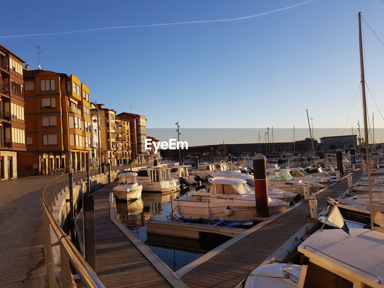 BOATS MOORED IN HARBOR AGAINST CLEAR SKY