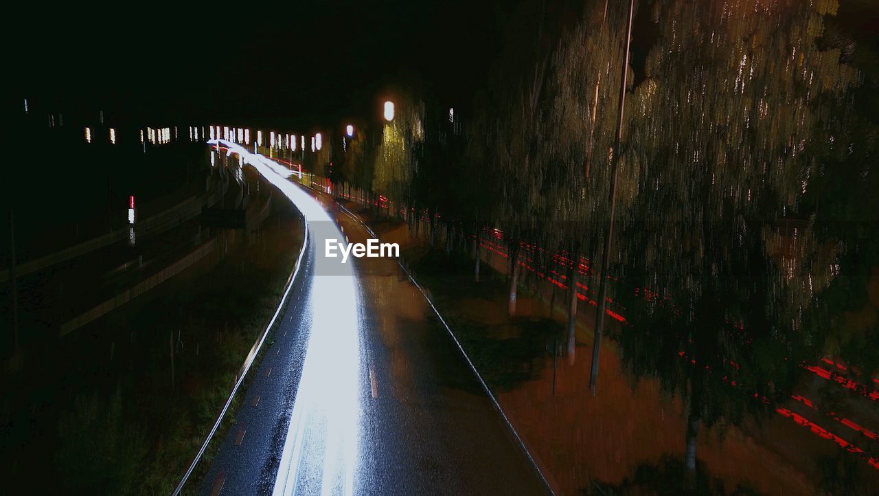 VIEW OF ILLUMINATED ROAD AT NIGHT