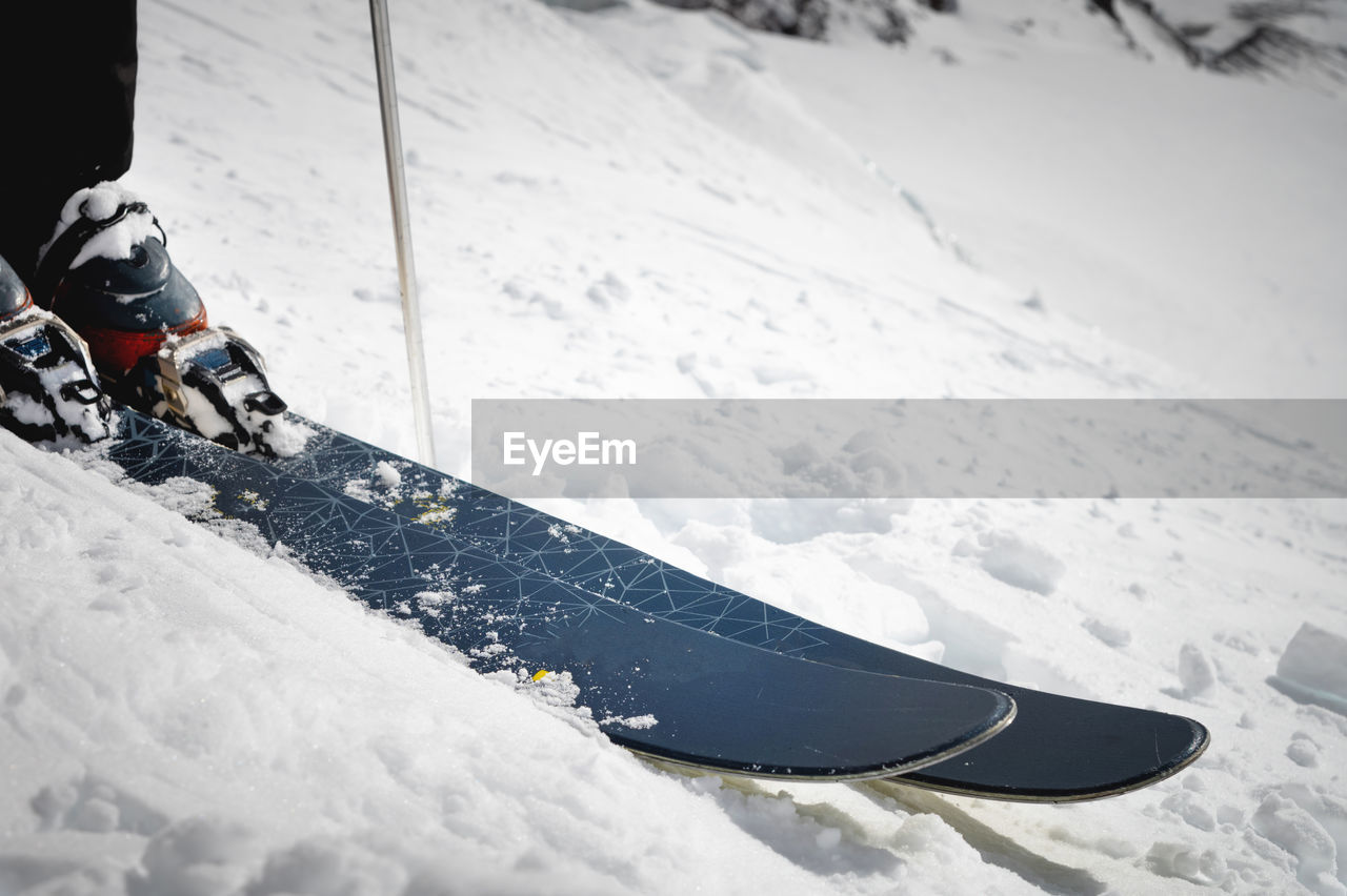 Close-up of boots and ski on a snow-covered mountain slope. extreme sport. winter sports concept