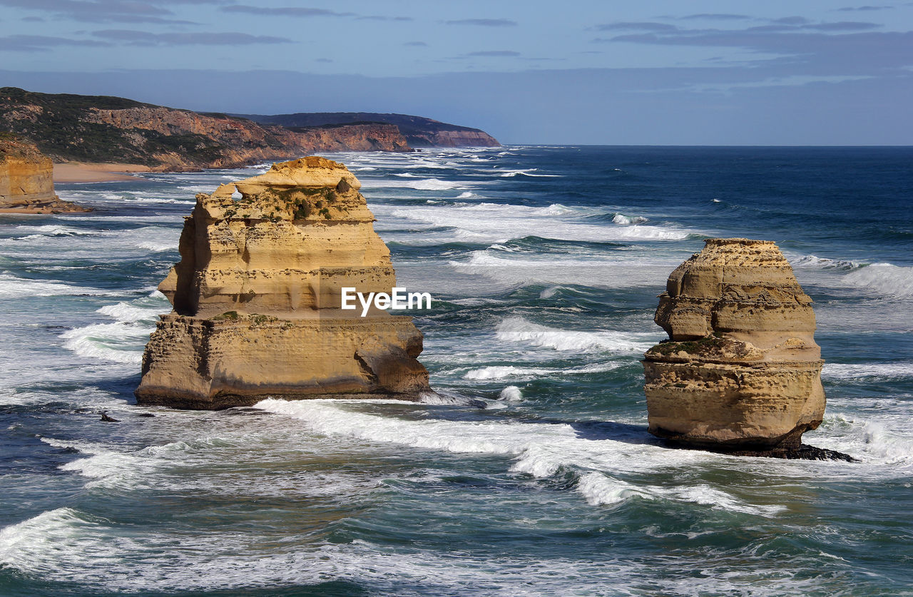 Rock formation on sea shore against sky