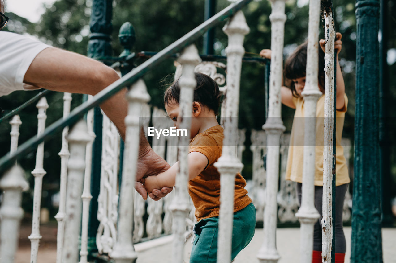 SIDE VIEW OF BOY LOOKING AT METAL RAILING