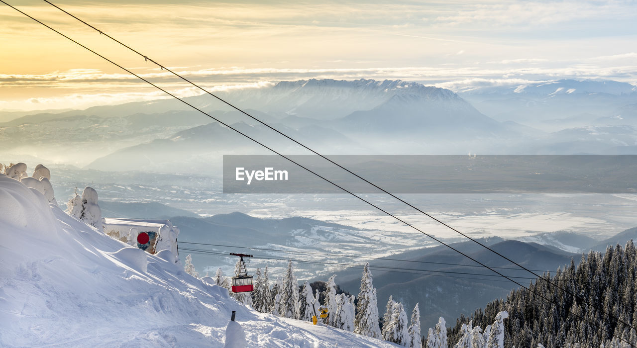 OVERHEAD CABLE CAR ON SNOWCAPPED MOUNTAINS