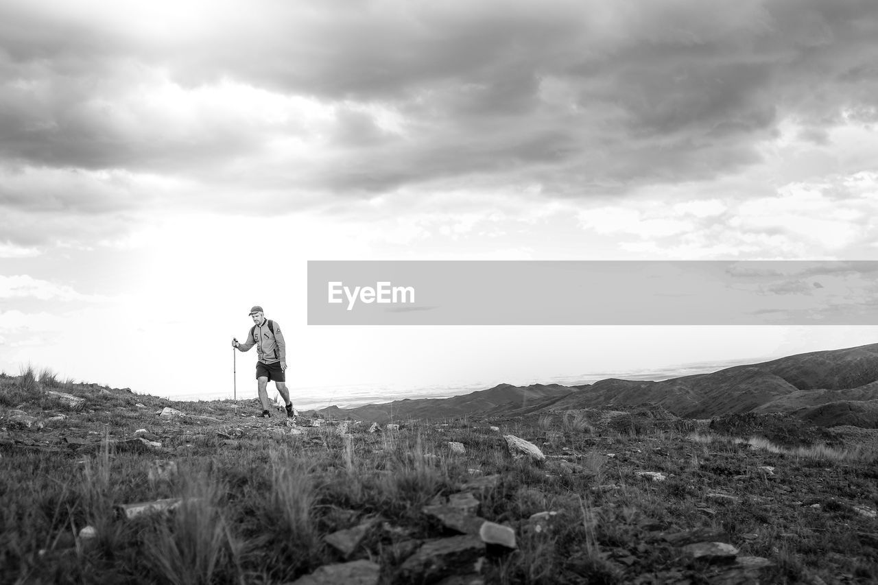 Man hiking on mountain against sky