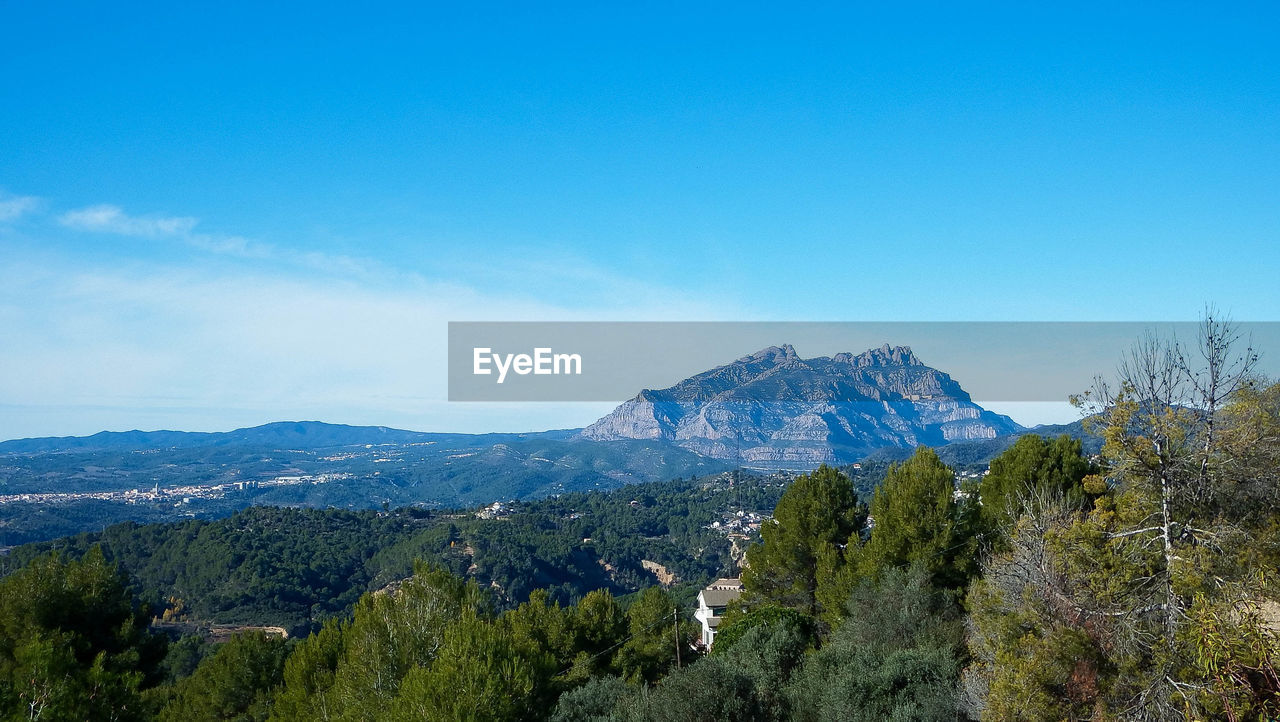 Panoramic view of landscape against blue sky