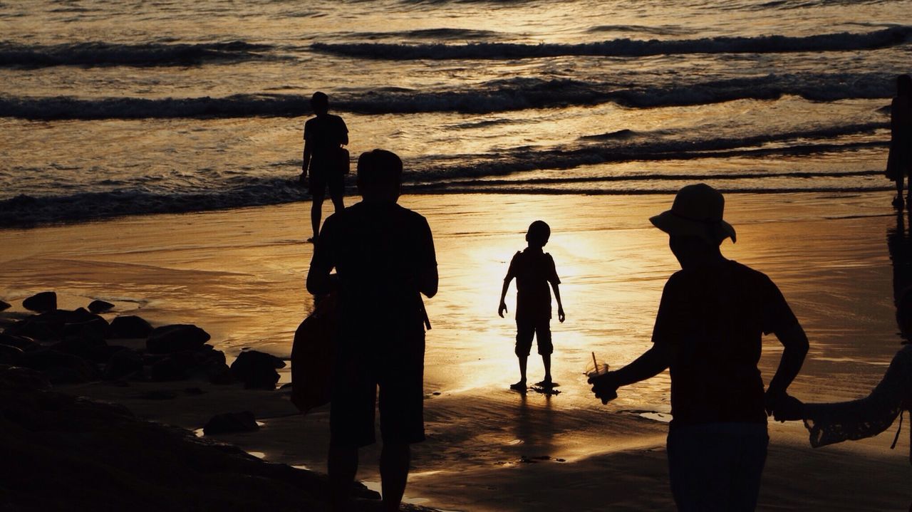 Silhouette people at beach during sunset