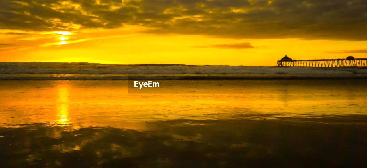 Scenic view of sea against orange sky