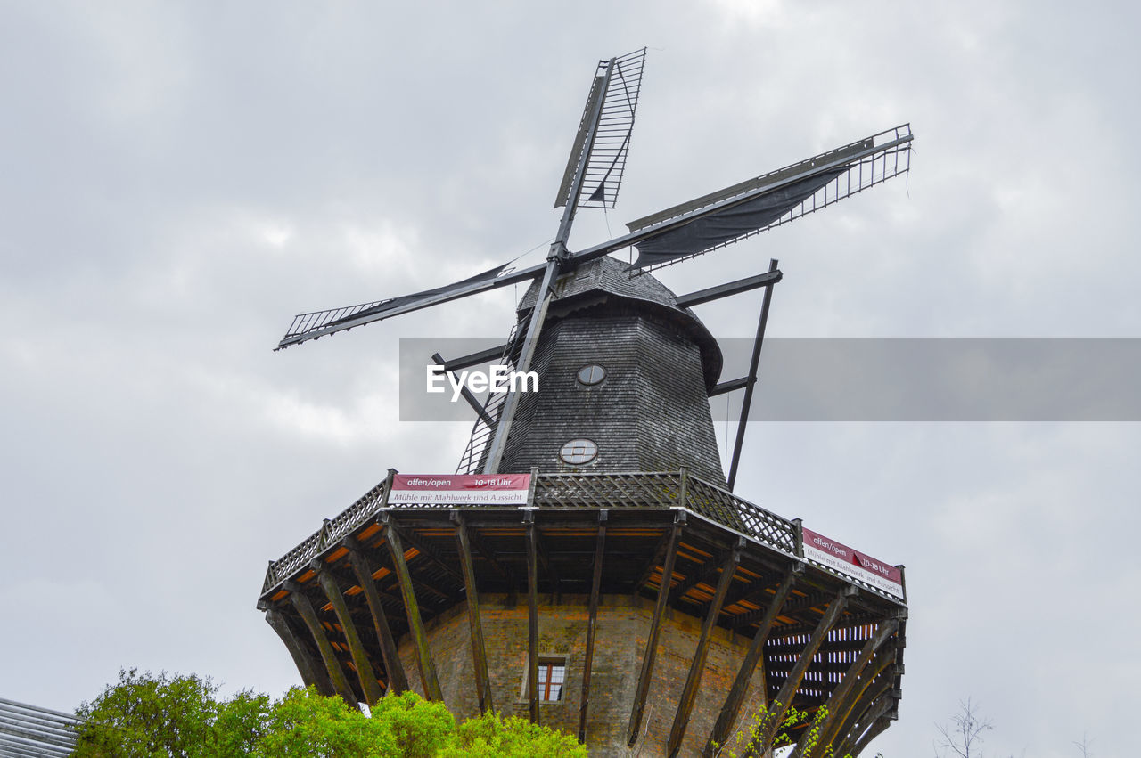 Low angle view of traditional windmill against sky