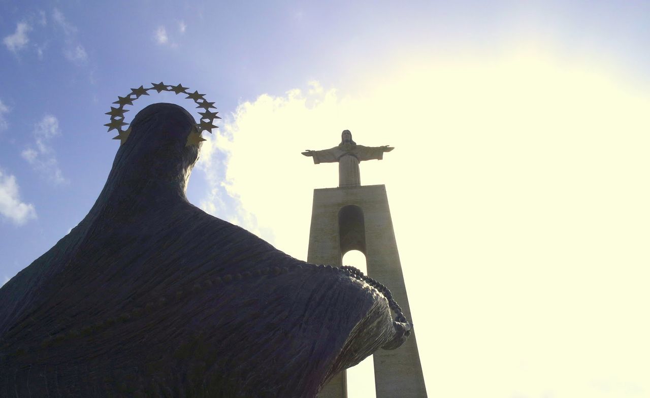 Low angle view of christ the king statue against cloudy sky