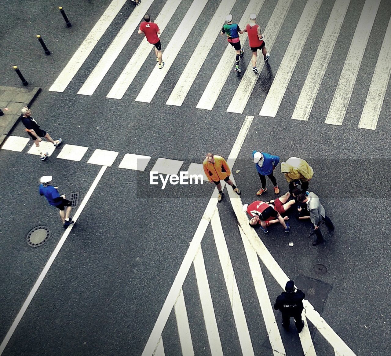 High angle view of people examining injured man on street