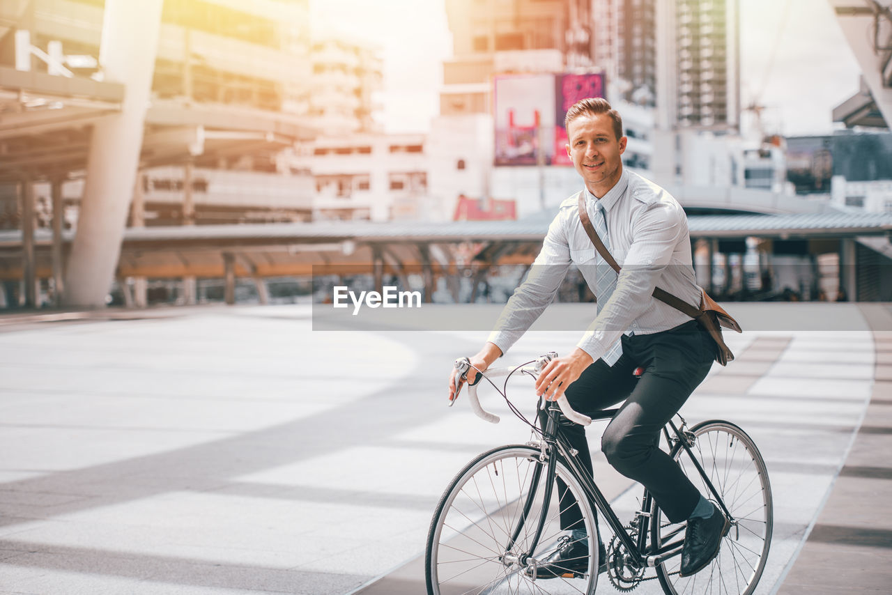 Portrait of smiling man riding bicycle on city street