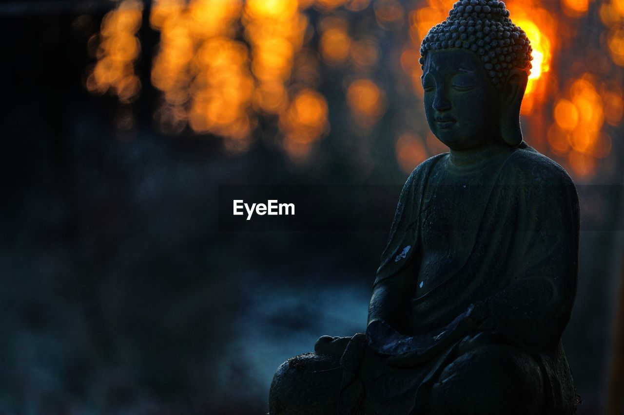 Statue of buddha against blurred background