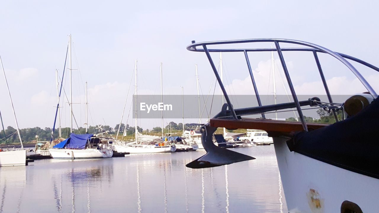 SAILBOATS MOORED AT HARBOR