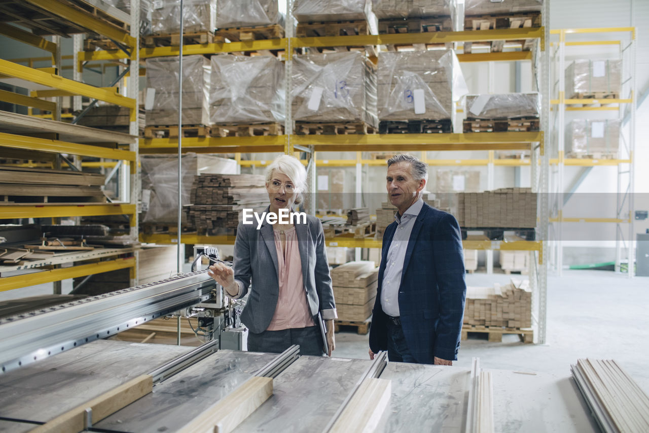 Business people analyzing wooden planks at industry