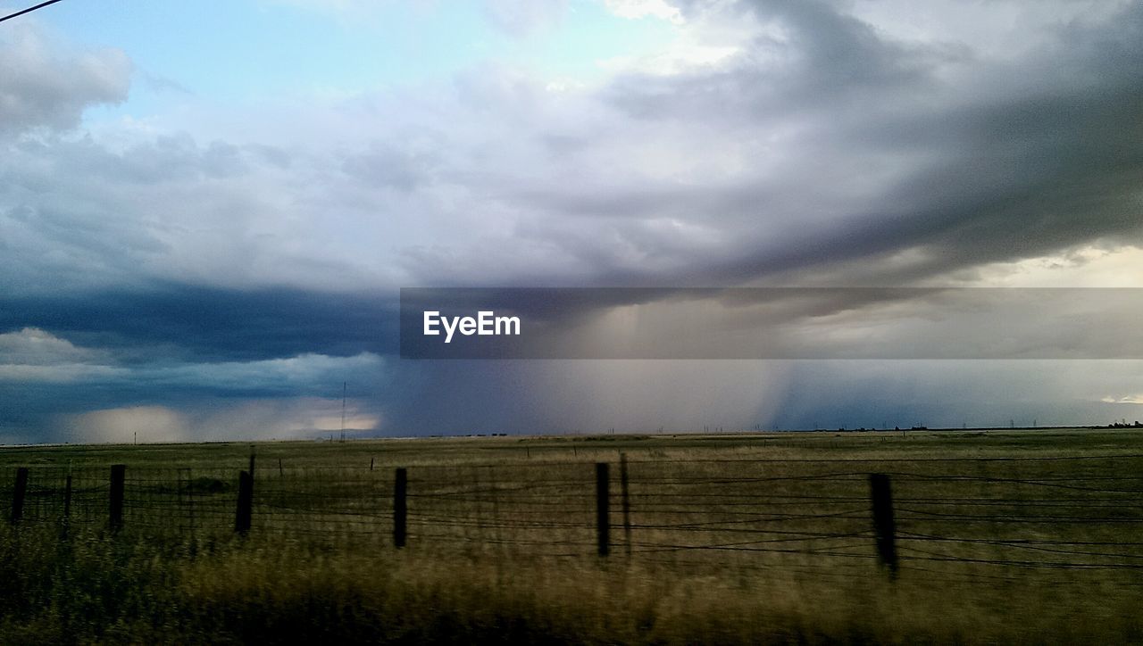 VIEW OF FIELD AGAINST CLOUDY SKY