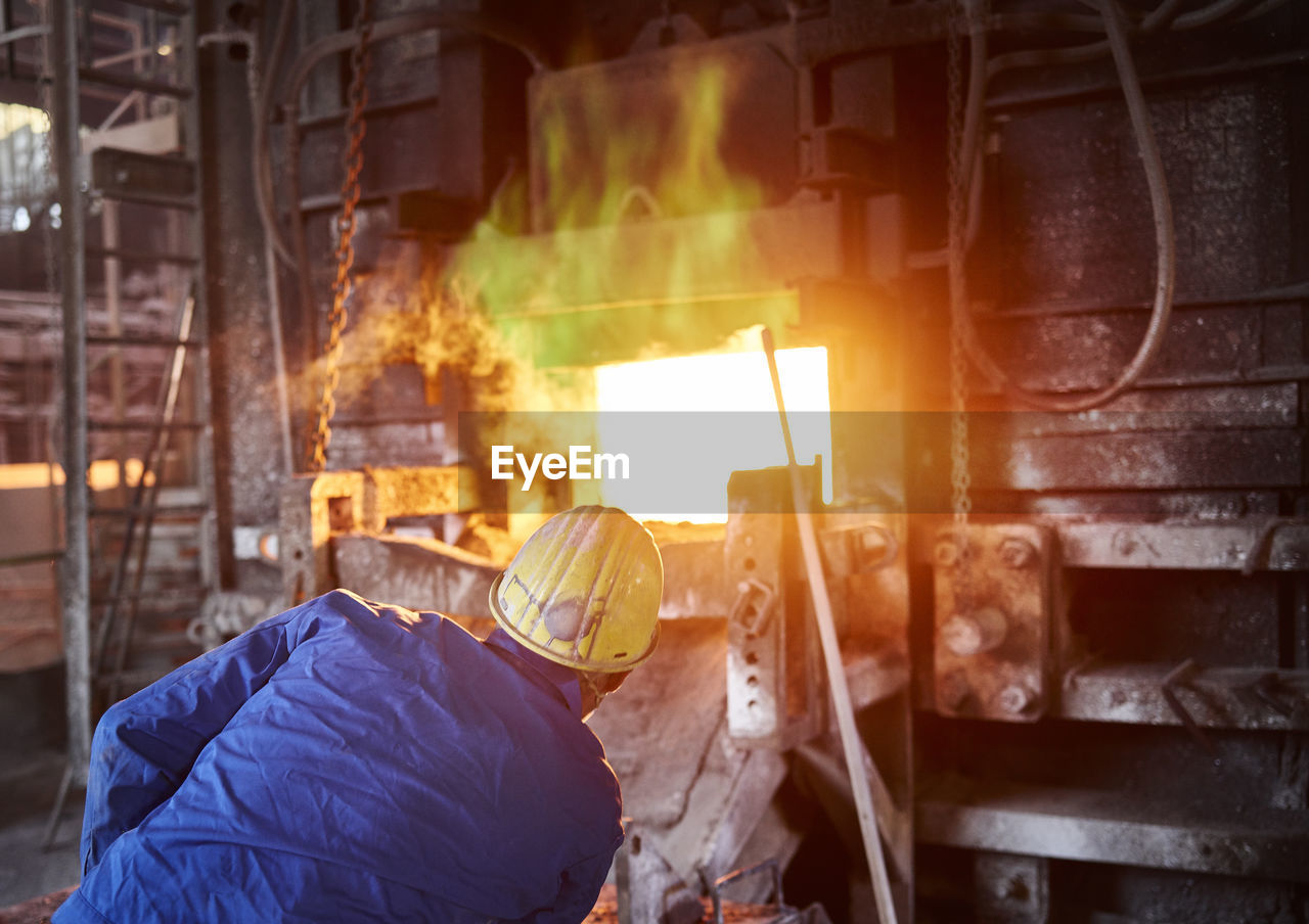 Industry, smeltery: worker checking blast furnace for fractures