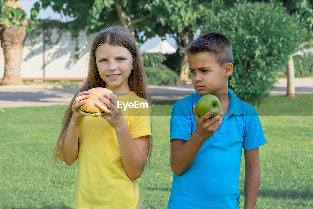 Children schoolchildren eat lunch in the park. harmful and healthy food.