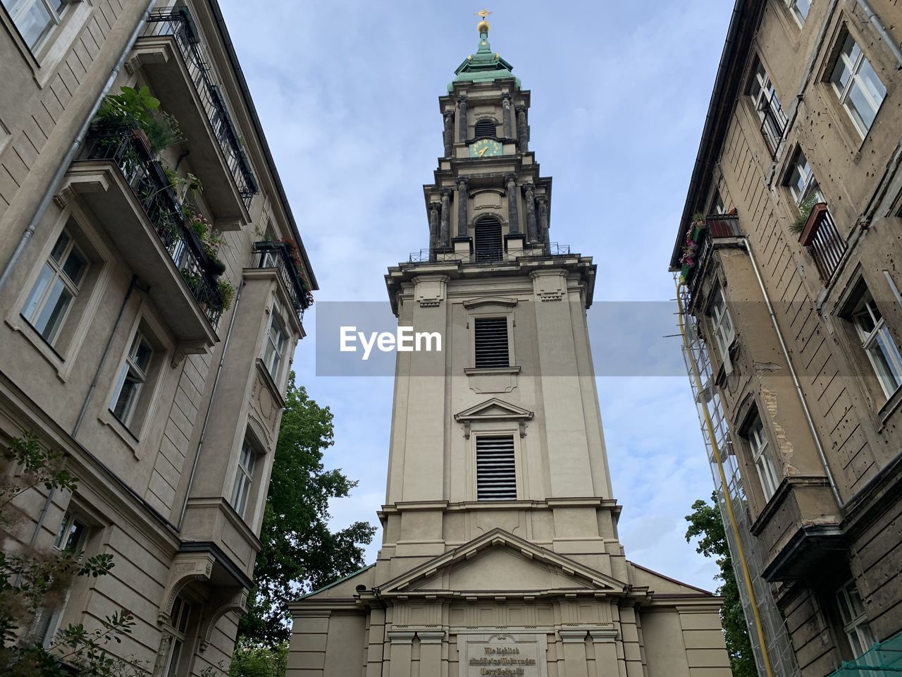 LOW ANGLE VIEW OF CLOCK TOWER AMIDST BUILDINGS IN CITY