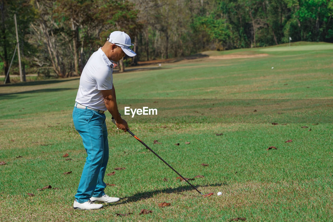 Full length of man playing golf in course