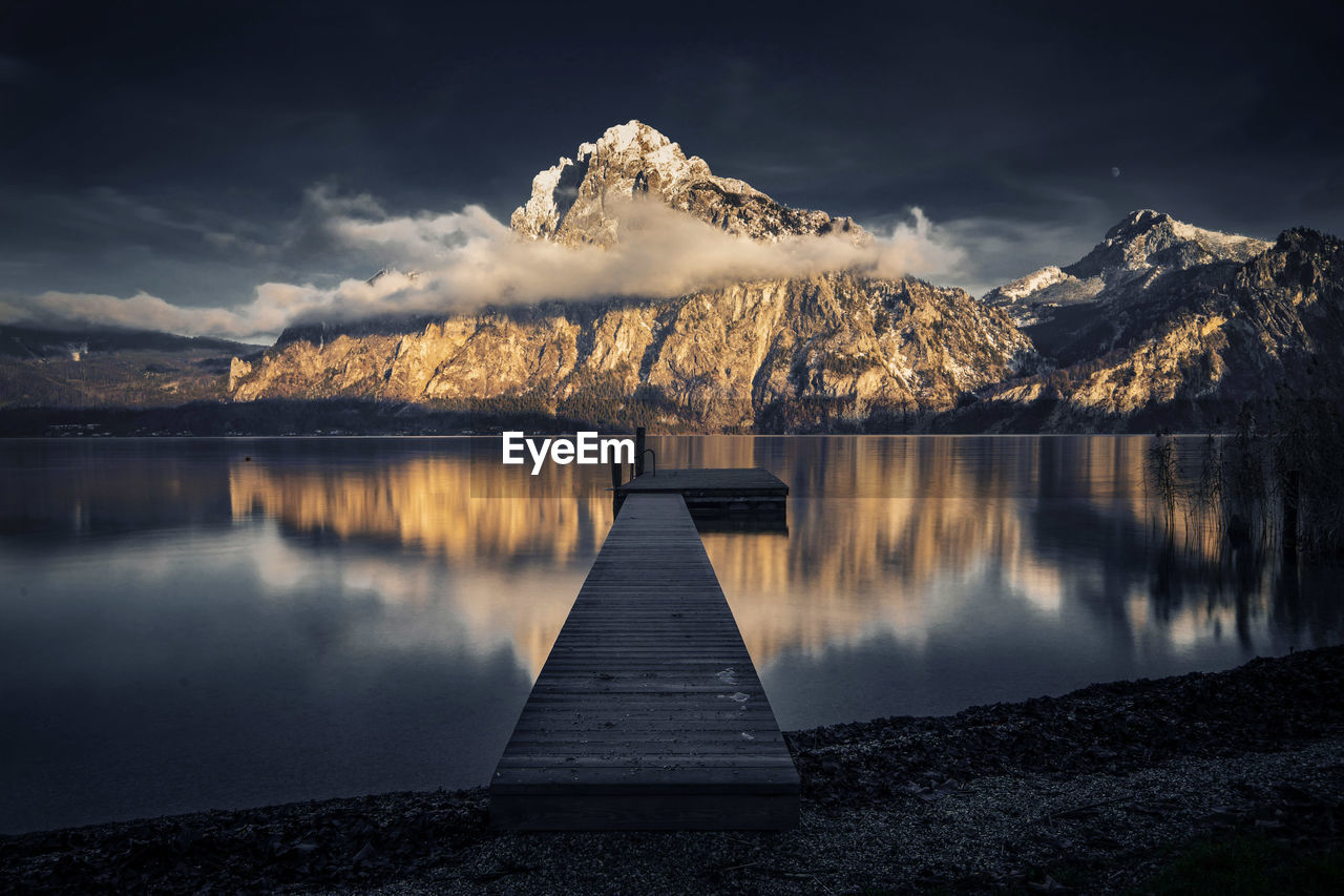 Scenic view of lake by mountains against sky