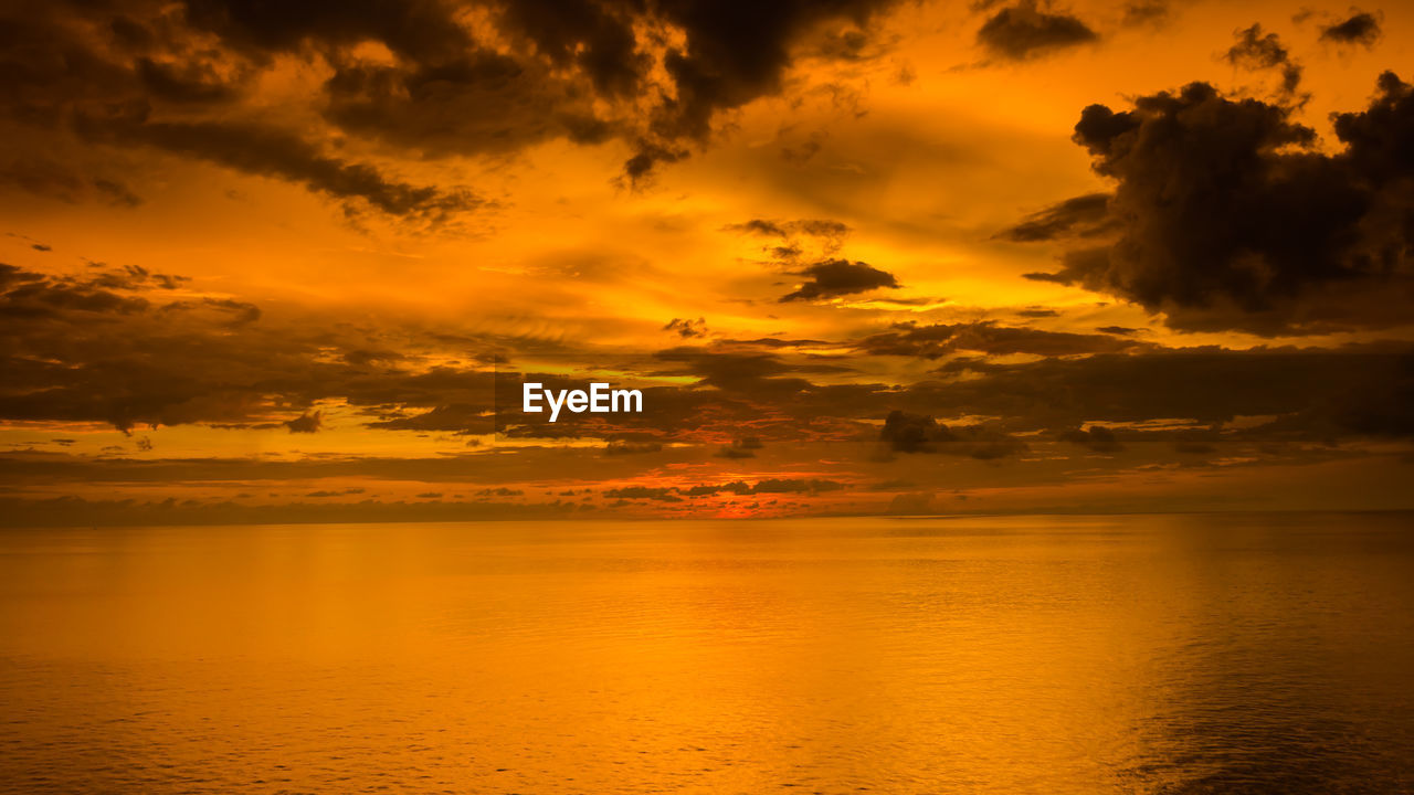 Scenic view of sea against orange cloudy sky during sunset